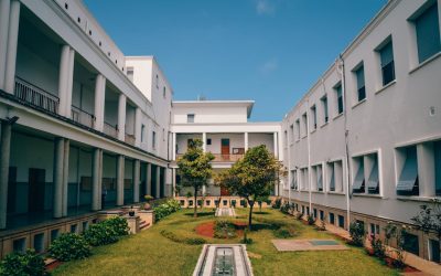 Elegant university building with garden courtyard in Rabat, Morocco under clear blue sky.