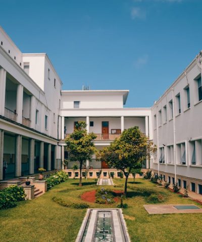 Elegant university building with garden courtyard in Rabat, Morocco under clear blue sky.